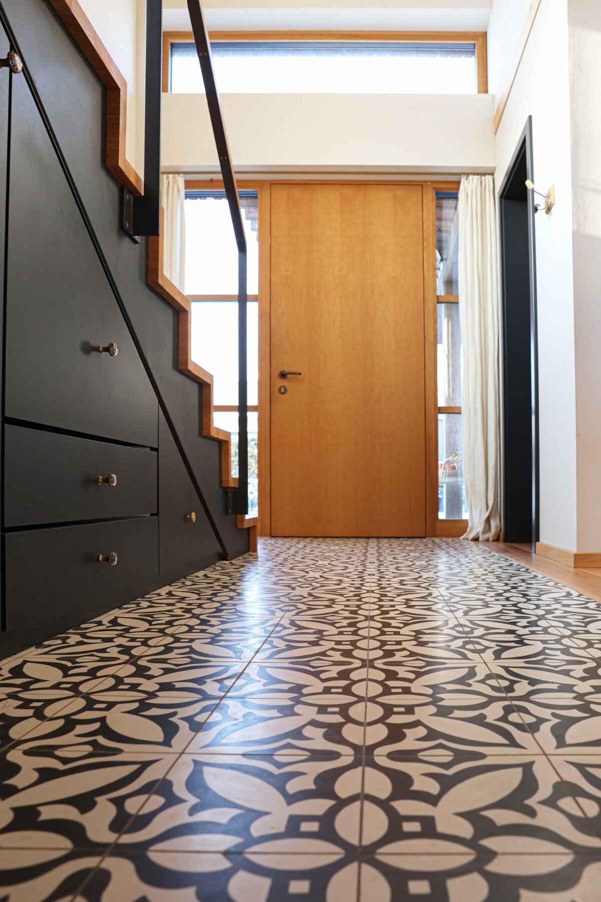 Eingangsbereich mit grafischem Fliesenboden und Einbauschrank